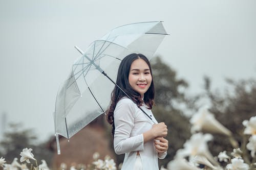 拿着伞的妇女佩带的白色长袖衬衣 · 免费素材图片