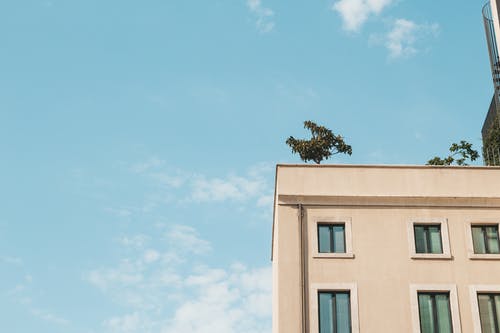 多云的天空下的棕色混凝土建筑 · 免费素材图片