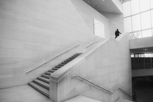 人走上楼梯灰度照片 · 免费素材图片