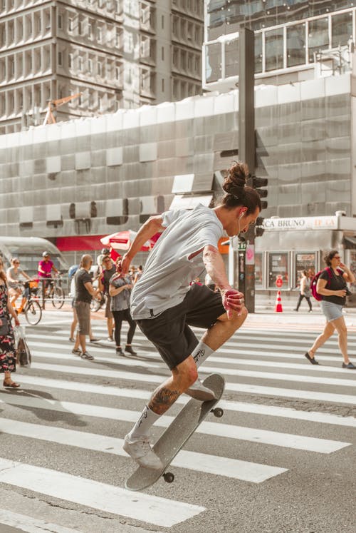 男子骑马滑板在行人上的照片 · 免费素材图片