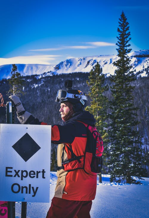 男子站在专家的唯一标牌附近 · 免费素材图片