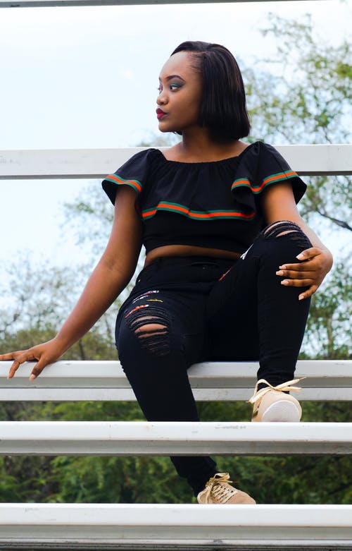 女人坐在长椅上，向右看 · 免费素材图片