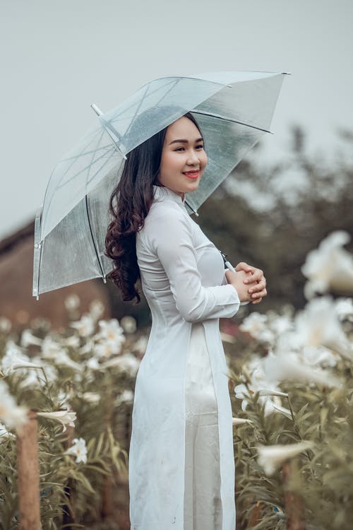 拿着伞的白色连衣裙的女人 · 免费素材图片