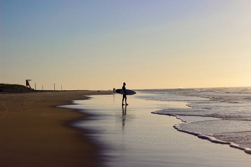 人在岸上举行冲浪板 · 免费素材图片