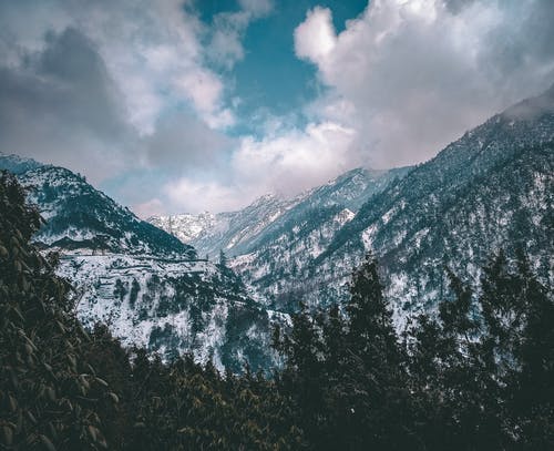 多云的天空下满雪的山 · 免费素材图片