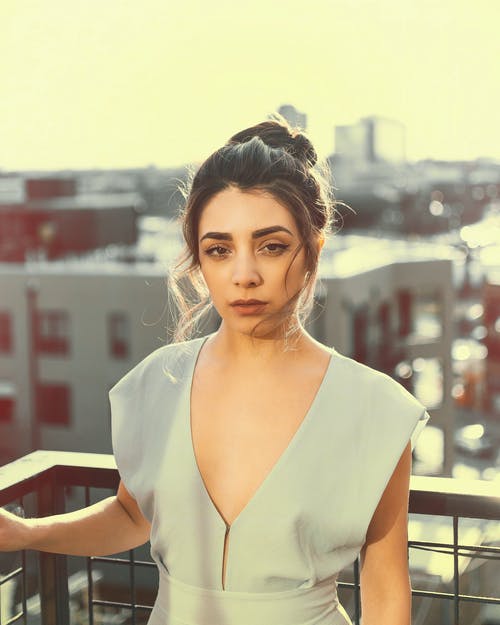 女人站在栏杆旁 · 免费素材图片