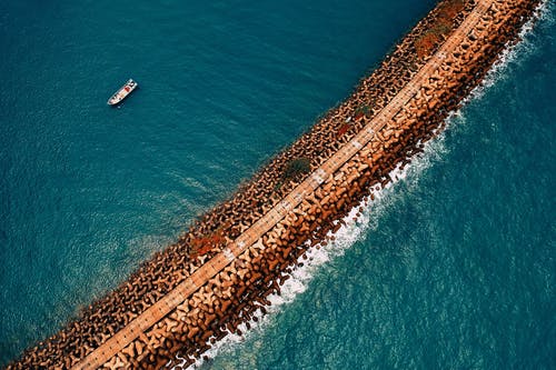 船在岩层附近的水体上 · 免费素材图片