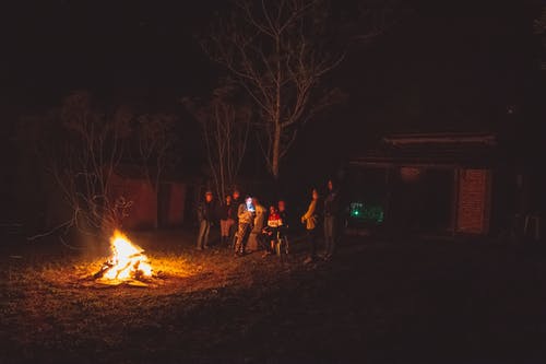 夜间站在篝火旁的人 · 免费素材图片