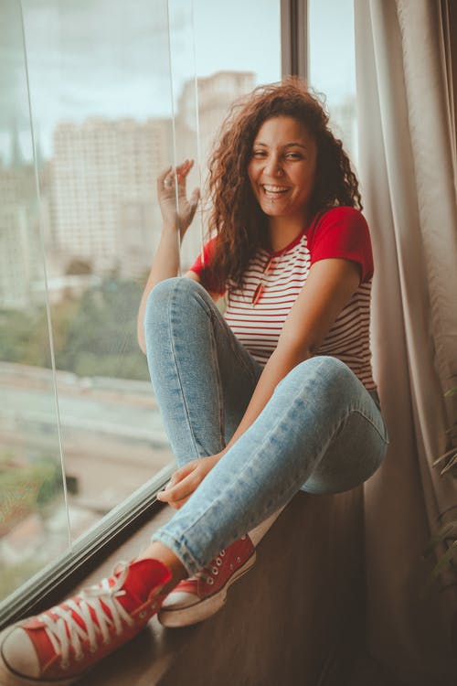 坐在窗户旁边的女人的照片 · 免费素材图片