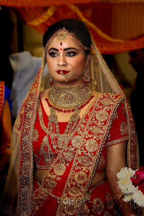 女人穿着红色和金色纱丽婚纱 · 免费素材图片