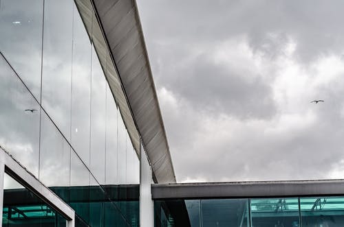 多云的天空下的玻璃建筑的照片 · 免费素材图片