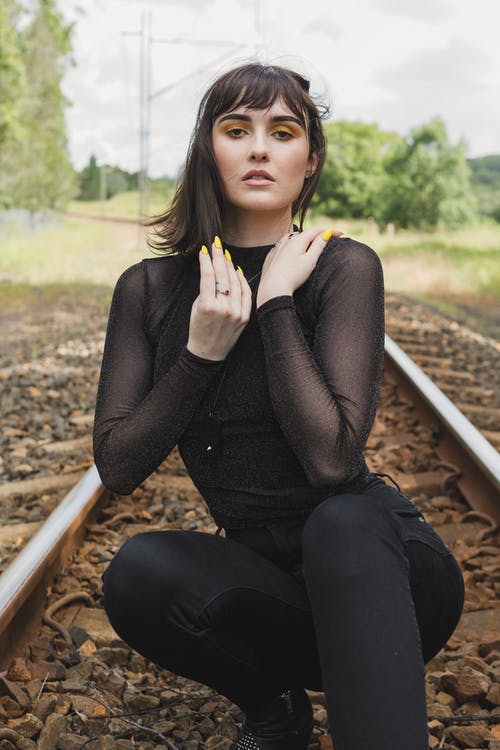 蹲在火车轨道上的女人 · 免费素材图片