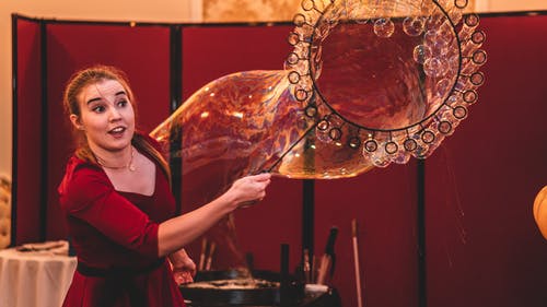 女人穿着红顶使巨泡 · 免费素材图片