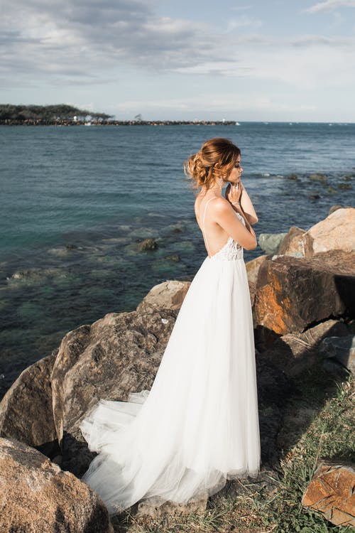白色婚纱站在岩石上的女人 · 免费素材图片