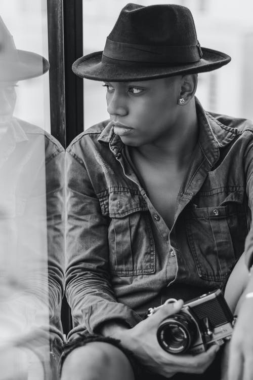 男子手持黑色相机 · 免费素材图片