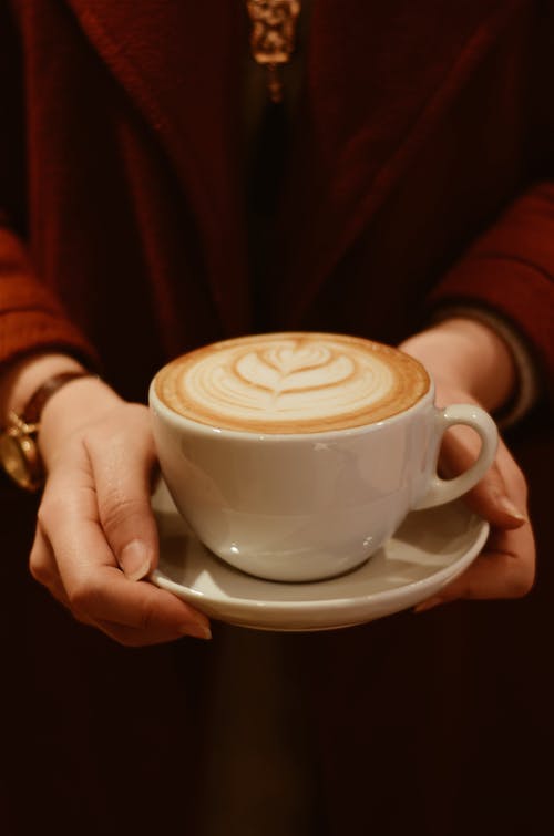 拿着杯咖啡的人的特写照片 · 免费素材图片