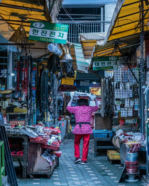 在商店之间的通路上行走的女人 · 免费素材图片