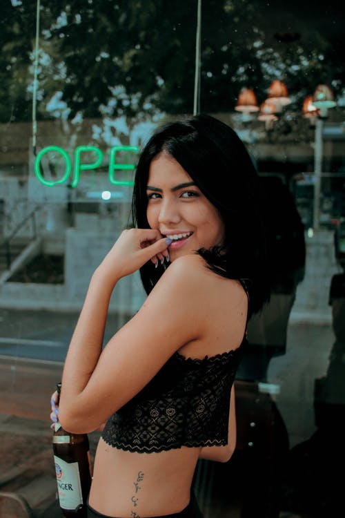 拿着瓶微笑的女人的照片 · 免费素材图片