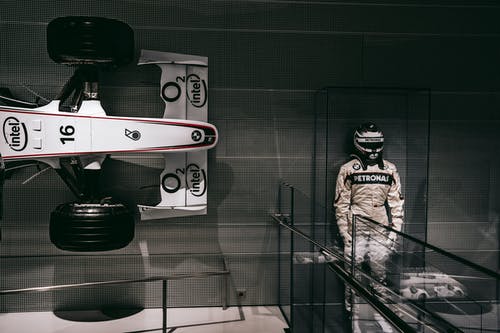 F1赛车旁边的f1驾驶员雕像 · 免费素材图片