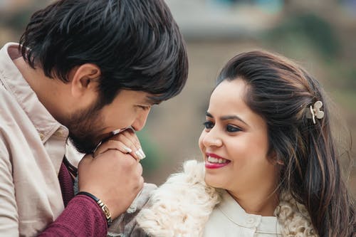 男人亲吻女人的手的特写照片 · 免费素材图片