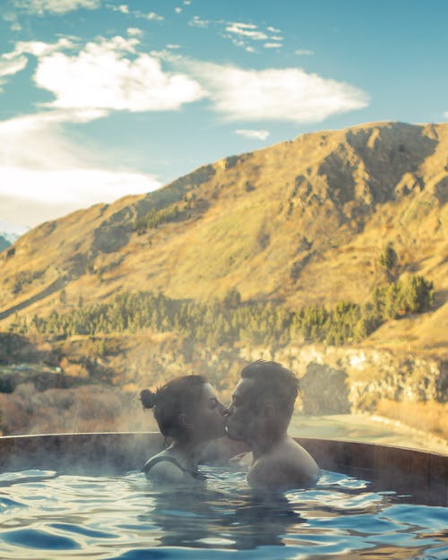 男人和女人在亲吻时浸入游泳池 · 免费素材图片