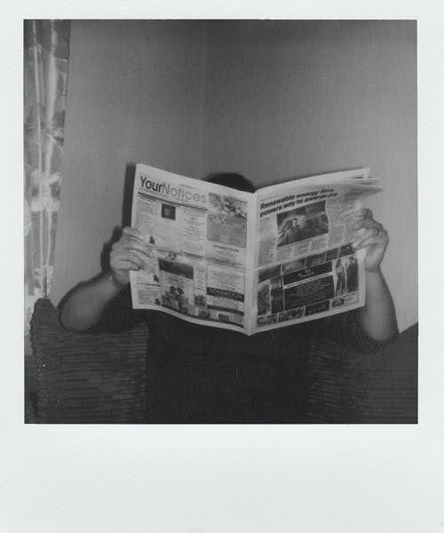 人阅读报纸的灰度摄影 · 免费素材图片