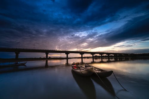 两船停靠在桥附近 · 免费素材图片