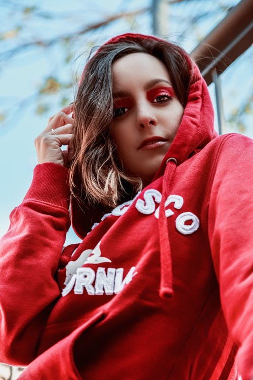 女人抚摸她的连帽衫 · 免费素材图片