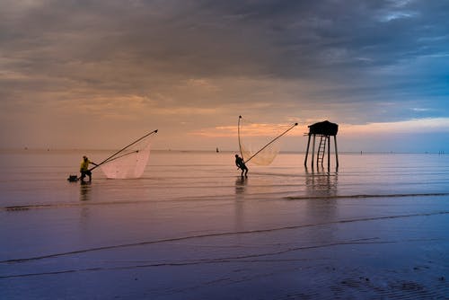 人们在海洋上使用网捕鱼 · 免费素材图片
