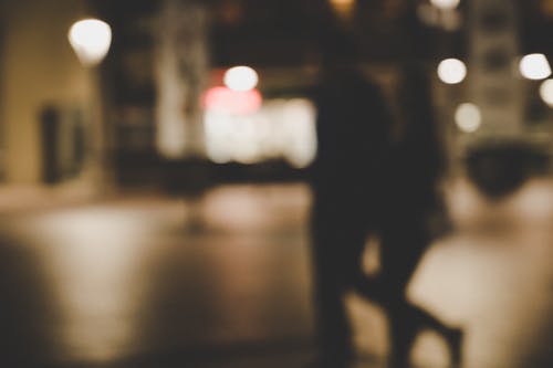 一对夫妇在街上行走的模糊图像 · 免费素材图片