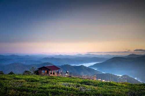俯瞰山谷的山顶上的棕色凉亭 · 免费素材图片