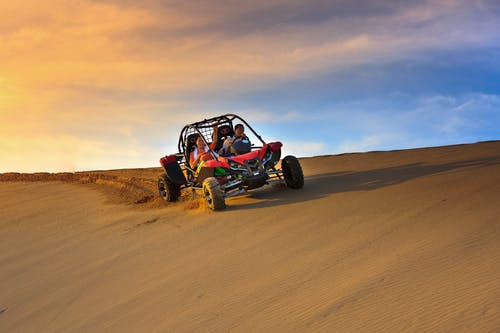 人在沙漠上骑沙丘越野车 · 免费素材图片