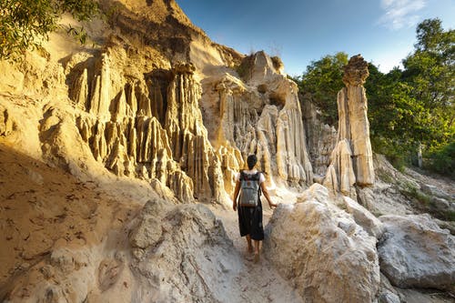 女人站在岩层附近 · 免费素材图片