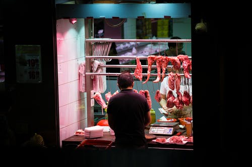 男子站在摊位前与绞肉 · 免费素材图片