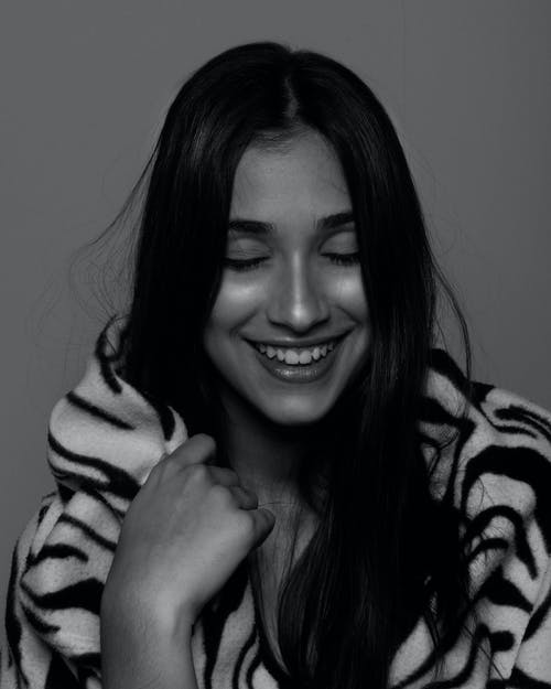 女人抱着她的斑马印花围巾咧着嘴笑 · 免费素材图片