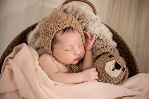 婴儿在睡觉时戴着棕色的针织帽 · 免费素材图片