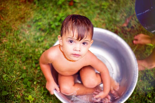 男孩在盆地上洗澡 · 免费素材图片