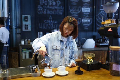 女人倒在杯子上的咖啡 · 免费素材图片