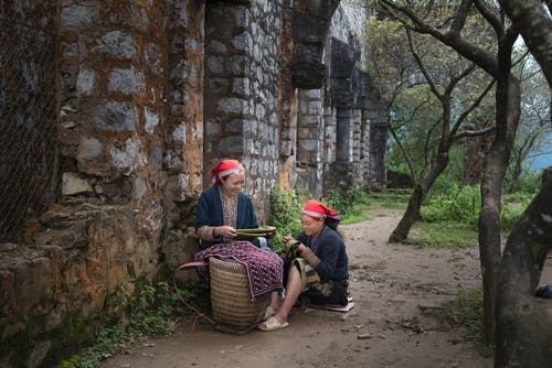 两个女人坐着微笑的照片 · 免费素材图片