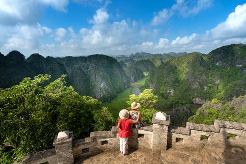 夫妇站在山前墙旁边 · 免费素材图片