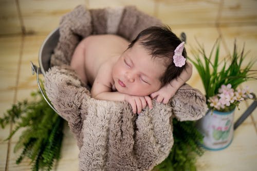 婴儿睡在棕色纺织 · 免费素材图片