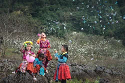 四个女孩在球场上玩泡泡 · 免费素材图片