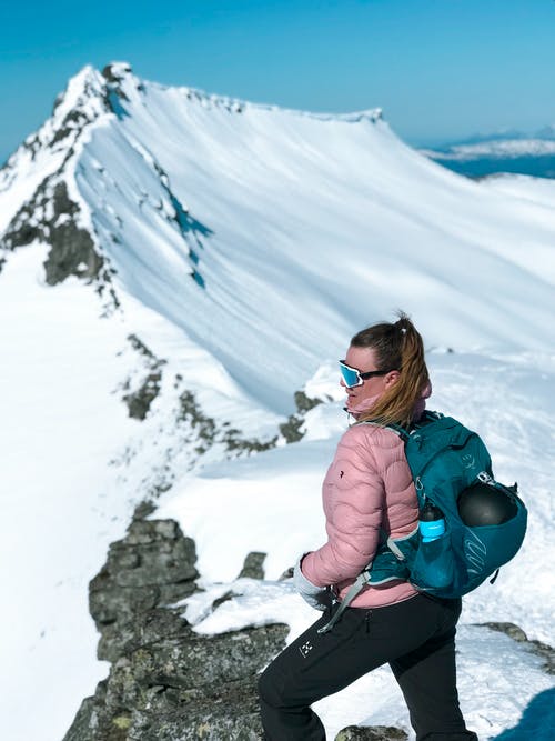 在雪山顶上的女人的照片 · 免费素材图片