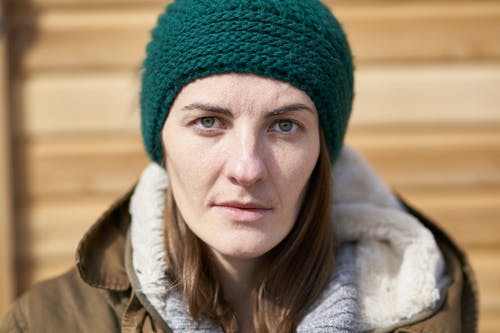 女人穿着绿色无檐小便帽的特写照片 · 免费素材图片