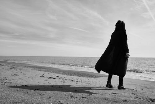 人站在海边的灰度照片 · 免费素材图片