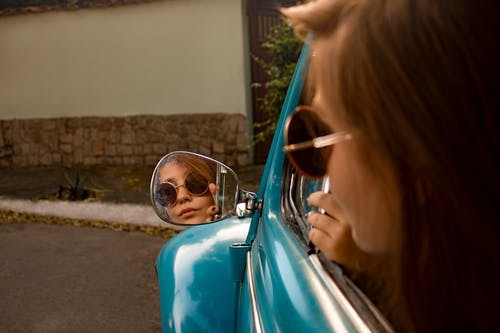 女人在车辆后视镜上观看 · 免费素材图片