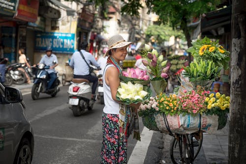 女人站在大街上的花瓣花上看 · 免费素材图片