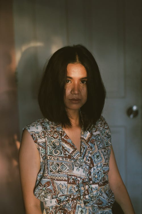 灰色和棕色的花无袖连衣裙站在门边的女人 · 免费素材图片