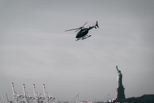 自由女神像附近的飞行直升机的照片 · 免费素材图片