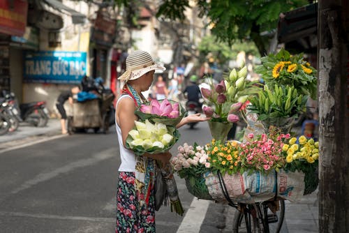 女人在路边卖花 · 免费素材图片